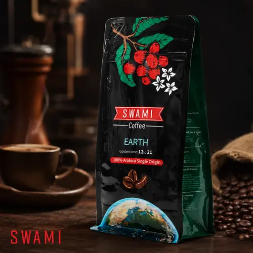 Black SWAMI Coffee packaging for the “FULL MOON” blend (100% Arabica, Golden Time: 12:21), adorned with coffee cherries and an earth graphic. Placed next to a glass Chemex coffee maker with freshly brewed coffee.
